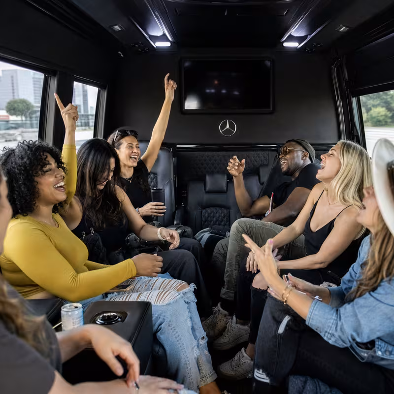 Group boarding a white charter bus for Concert Transportation transportation in Durham