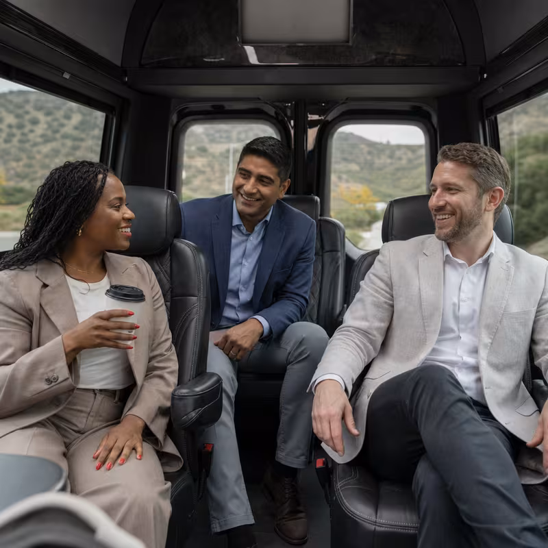 Group boarding a white charter bus for Corporate Transportation transportation in Durham