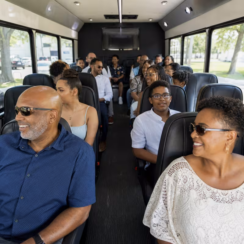 Group boarding a white charter bus for Private Event Transportation transportation in Durham