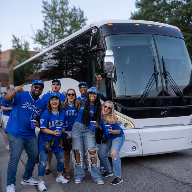 Passengers loading luggage while boarding an Durham group shuttle