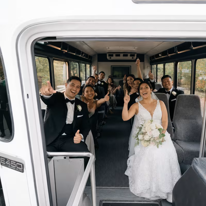 Group boarding a white charter bus for Wedding Transportation transportation in Durham